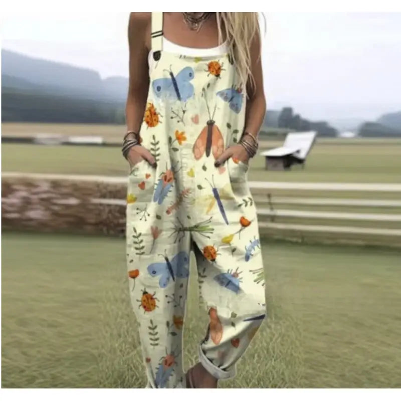Cream-colored printed suspender overalls featuring a playful pattern of blue orange and pink butterflies ladybugs and green foliage for casual wear.