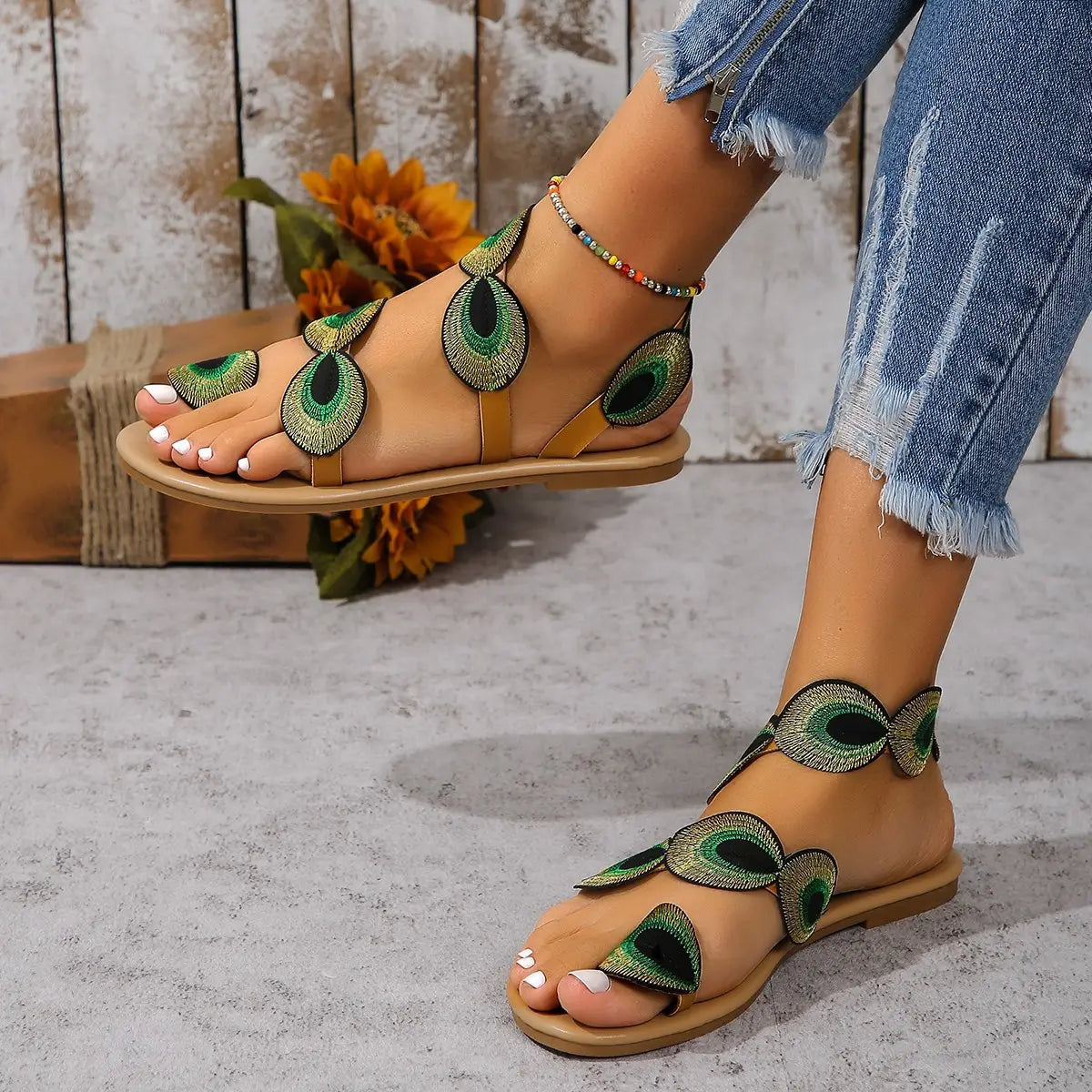 Peacock embroidery flat sandals for women in tan leather featuring green and black peacock-eye feather motifs.