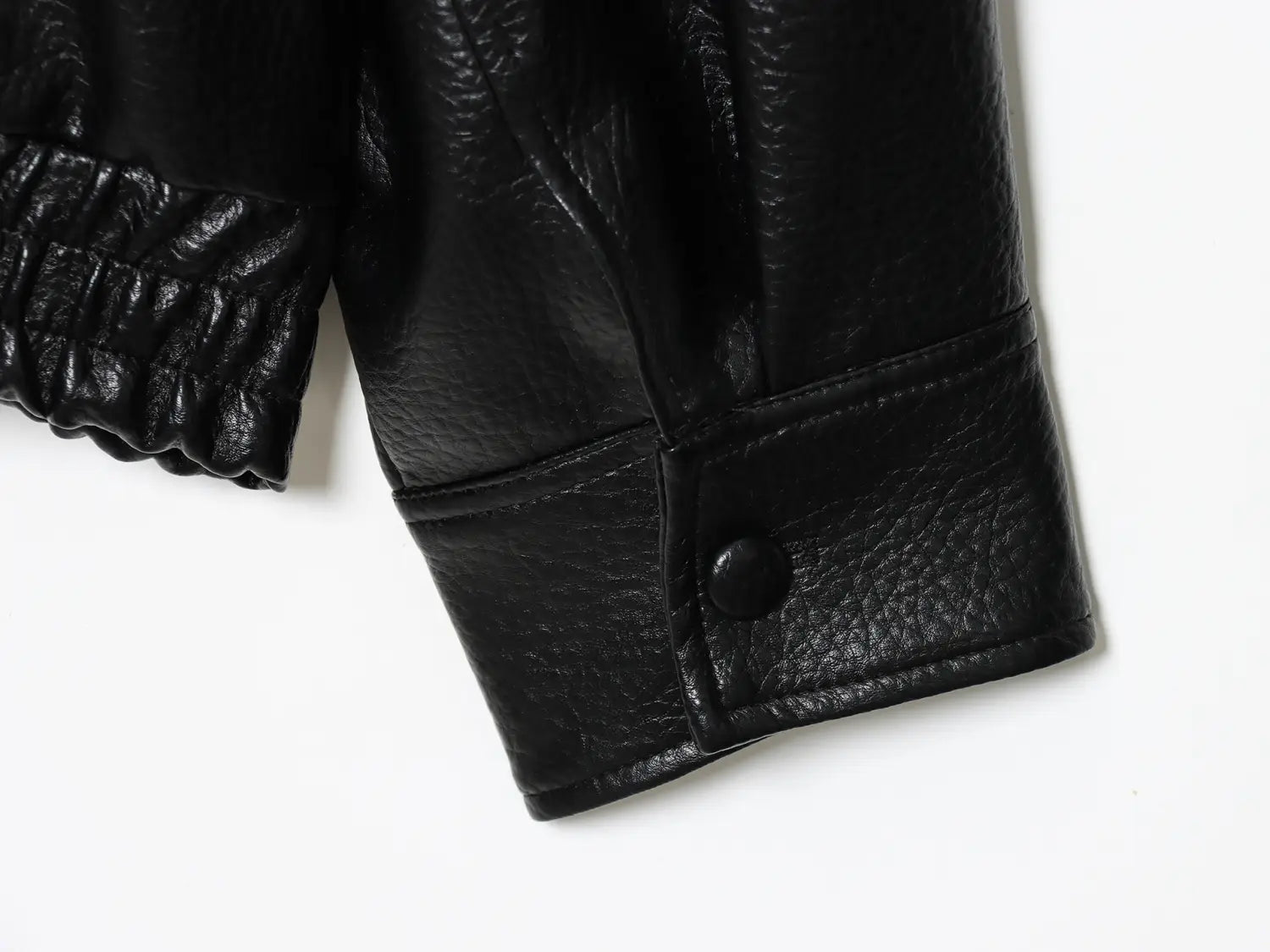 schwarze Damen-Motorradjacke mit hohem Stehkragen aus Kunstleder, Ärmelansicht mit strukturierter Oberfläche und elastischem Bündchen
