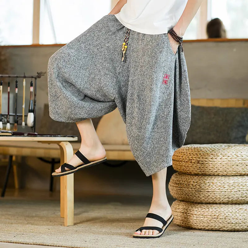 Herren-Shorts aus bedrucktem Baumwollstoff im Lantern-Harem-Look mit weitem Bein in Grau, mit einem roten bestickten Patches-Applikat an der Seite.