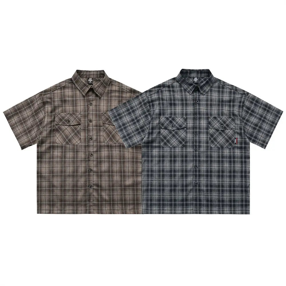 Two embroidered plaid short sleeve shirts in muted brown beige tones with a subtle fade effect and dark gray black, both featuring chest pockets and matching buttons.
