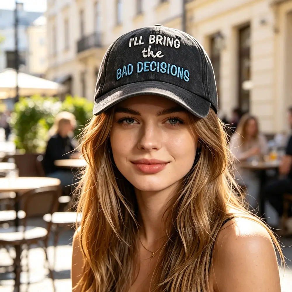 Black distressed baseball cap with embroidered white and light blue text reading i’ll bring the bad decisions for a humorous casual accessory.
