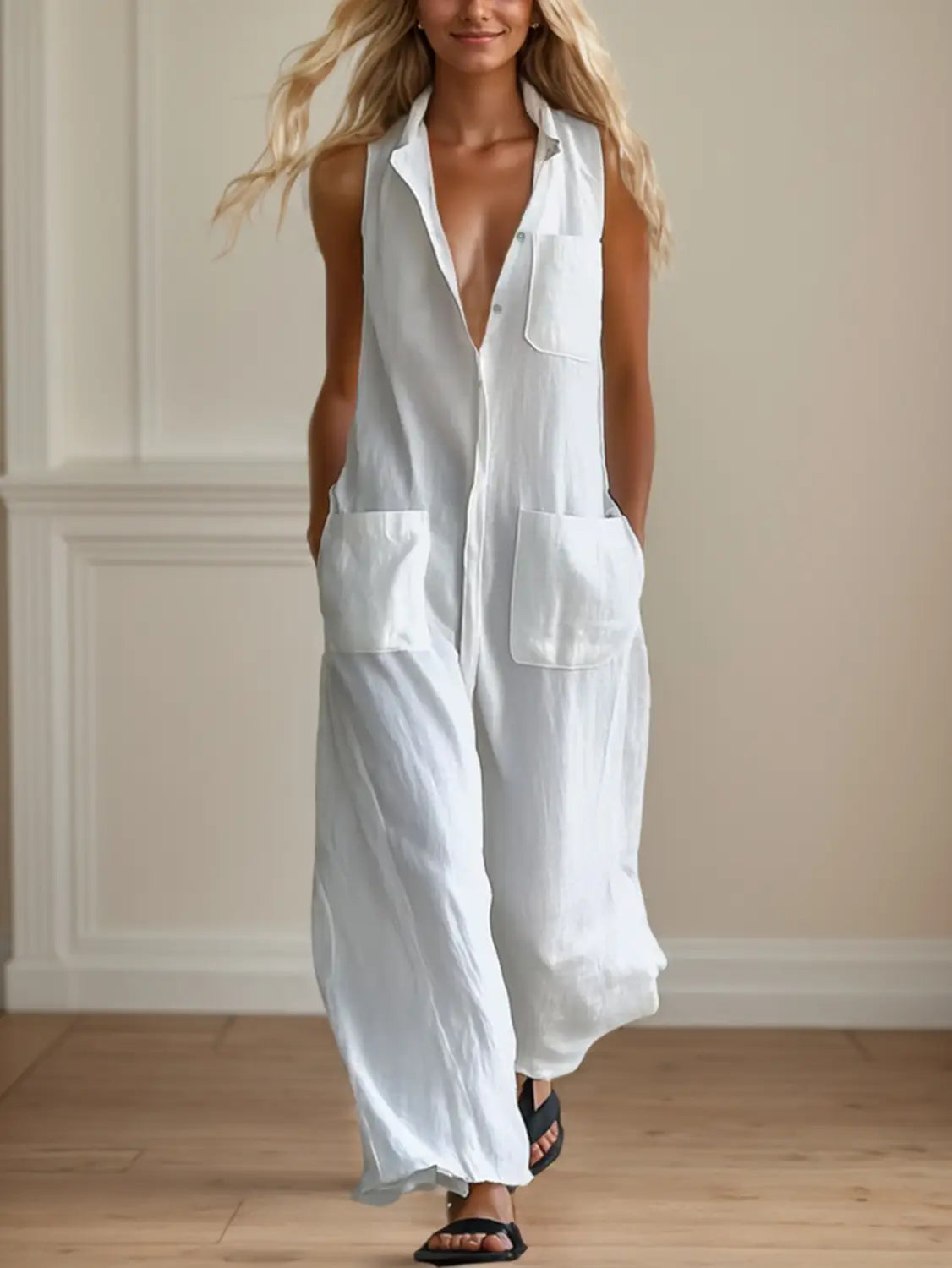 Combinaison blanche sans manches à jambes larges, dotée d’une fermeture boutonnée à l’avant, de poches et d’une silhouette ample et fluide.