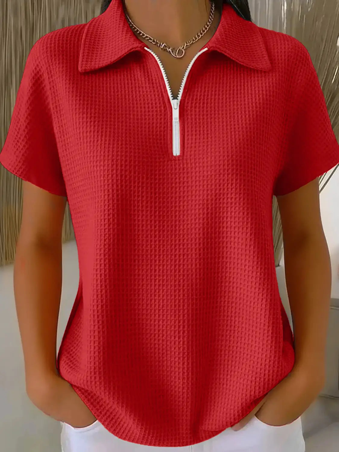 Red waffle knit half zip short sleeve polo shirt featuring a white zipper and collar.