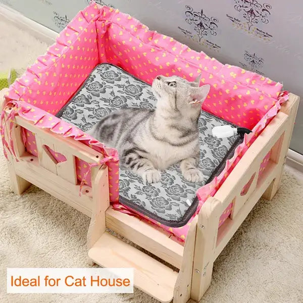 Pink and gold patterned fabric-lined wooden cat bed with a gray floral waterproof electric heated pet heating pad.