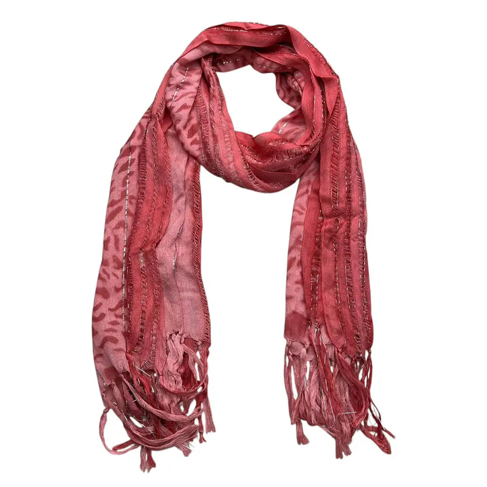 Un foulard en viscose rose poudré tacheté de léopard, doux et de couleur rose poudré, avec des fils métalliques, présentant un motif de léopard discret et des franges délicates.