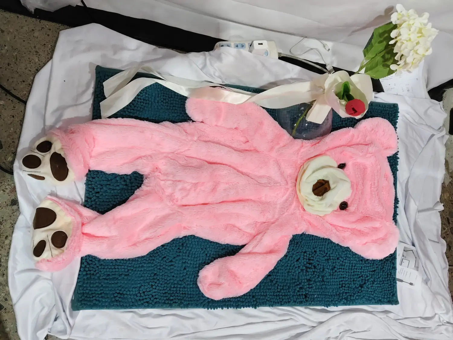 Pink giant teddy bear plush toy with white paw pads and cream-colored snout featuring an unfilled leather shell.
