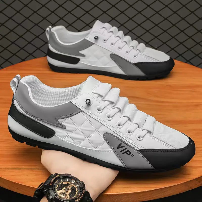 Men’s low top quilted athletic fashion sneakers in white and gray with black accents featuring a quilted texture on the toe box and vip branding on the side.