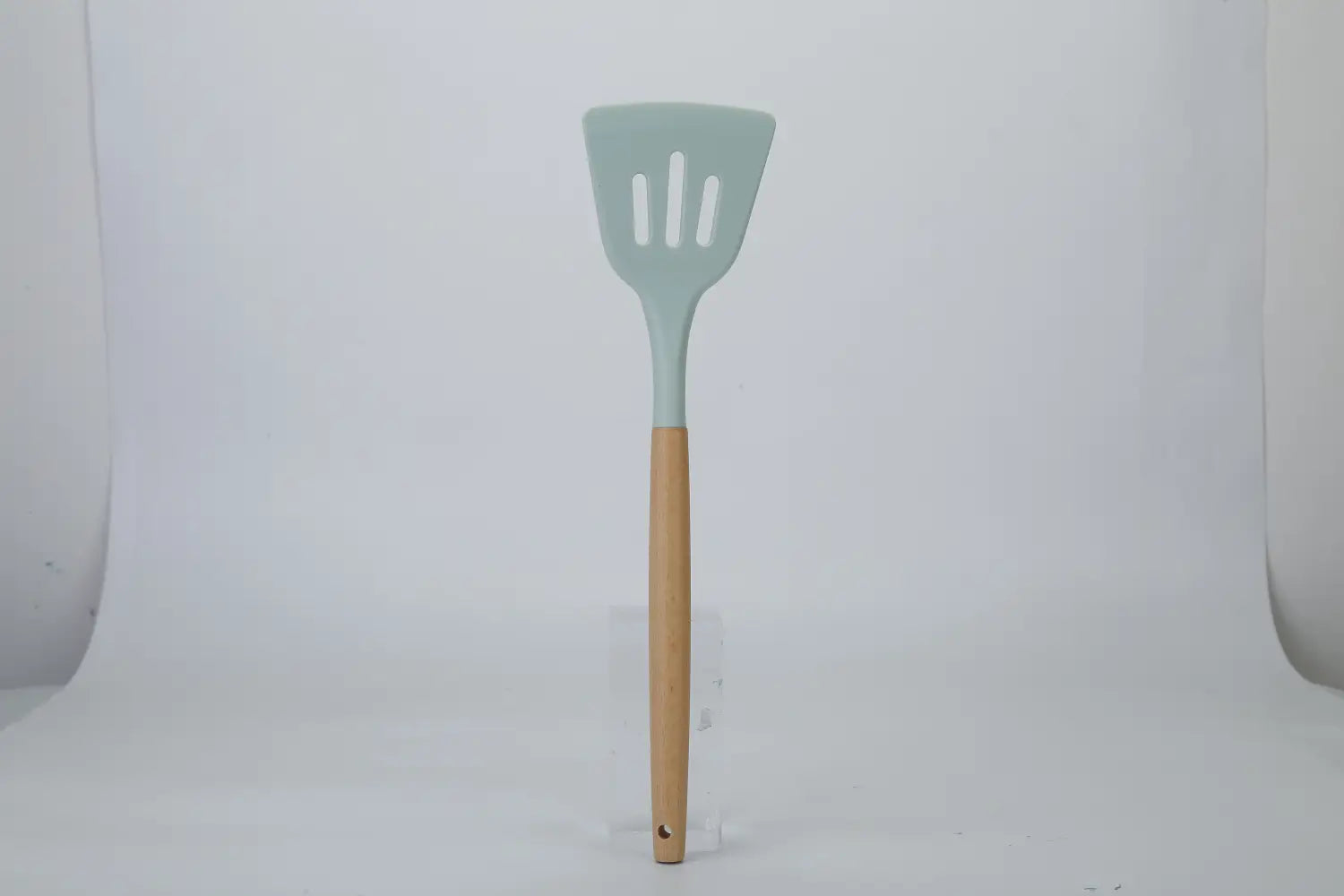 Light blue silicone spatula with a wooden handle from the silicone cooking utensil set 11pc designed for cooking.