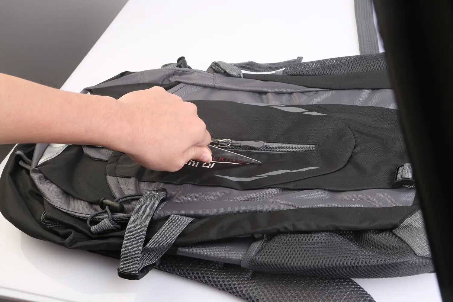Black and gray mesh 36l lightweight waterproof hiking backpack with reinforced straps and reflective stripes shown from the back side.