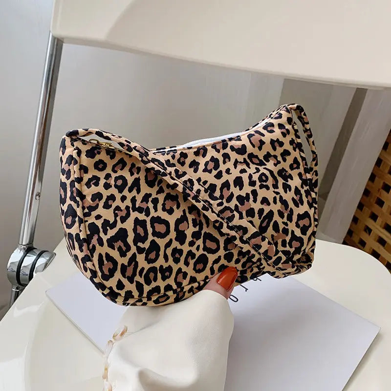 A beige and black leopard-print fabric crossbody bag with a sleek modern design for women.