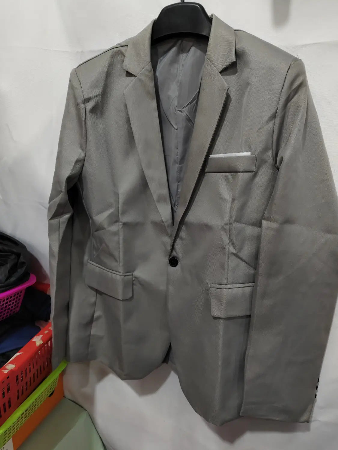 Herren-Slim-Fit-Fuchsia-Freizeitblazer in Grau mit einem einzelnen schwarzen Knopf und passendem Einstecktuch.