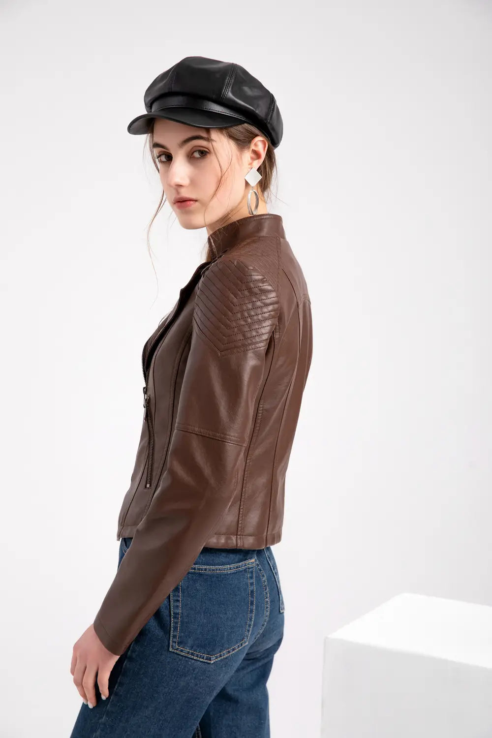 Braunes Faux-Leder-Motorradjacke mit wattierten Schulterpartien und hohem Kragen, entworfen als Schlank-Fit-Mantel für Damen.