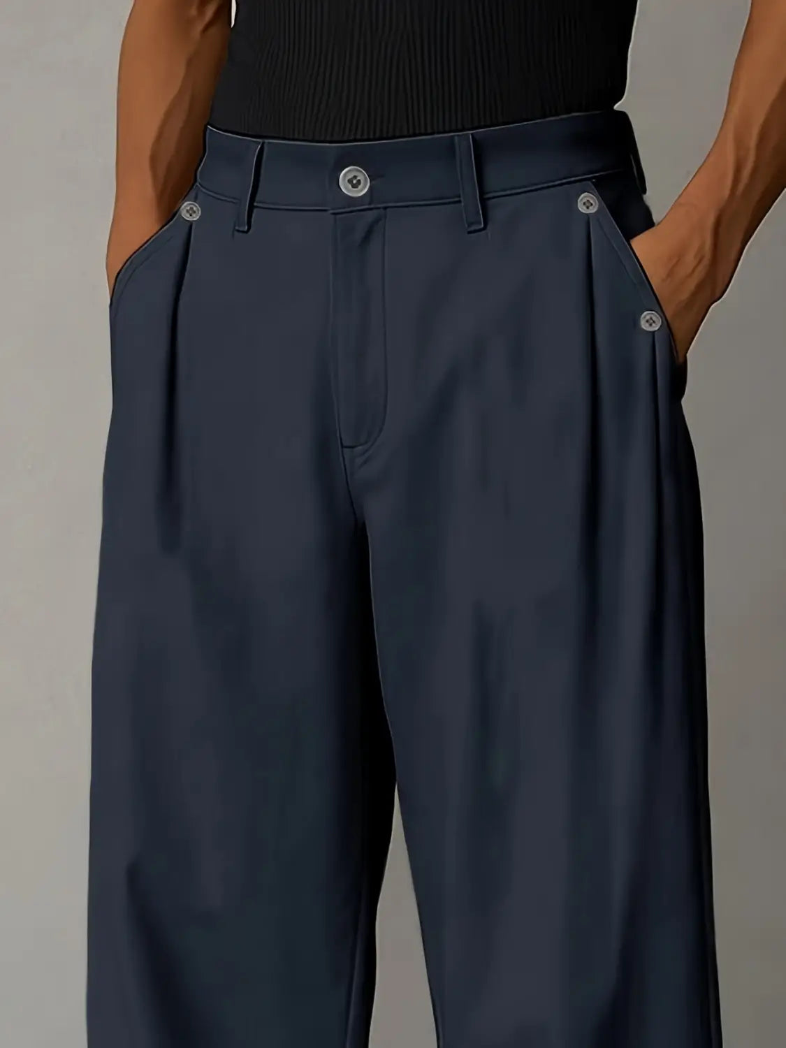 Des pantalons décontractés plissés à jambes larges bleu marine foncé pour hommes, présentant des détails de boutons à la finition argentée.