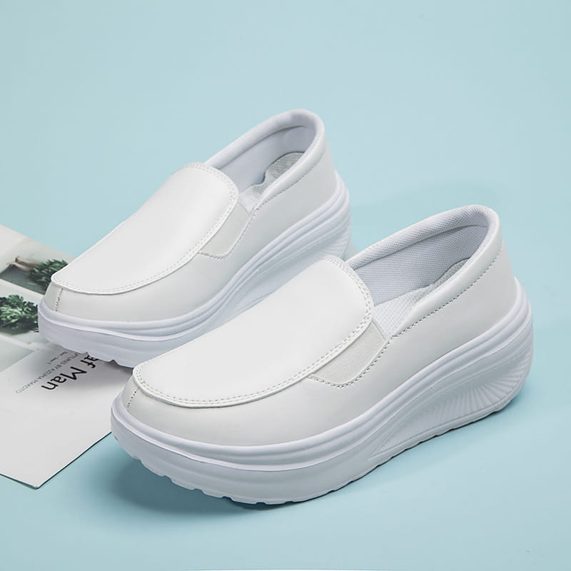 Chaussures en cuir à talon compensé en forme de coin blanches, modèle slip-on, avec une semelle épaisse rembourrée et dessus lisse.