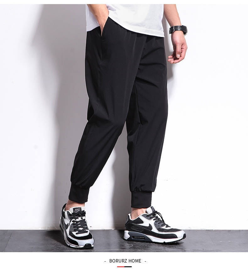 Pantalon de jogging athlétique pour hommes grande taille en noir, avec coupe décontractée, jambes fuselées et poignets élastiques conçus pour le confort et le port décontracté.