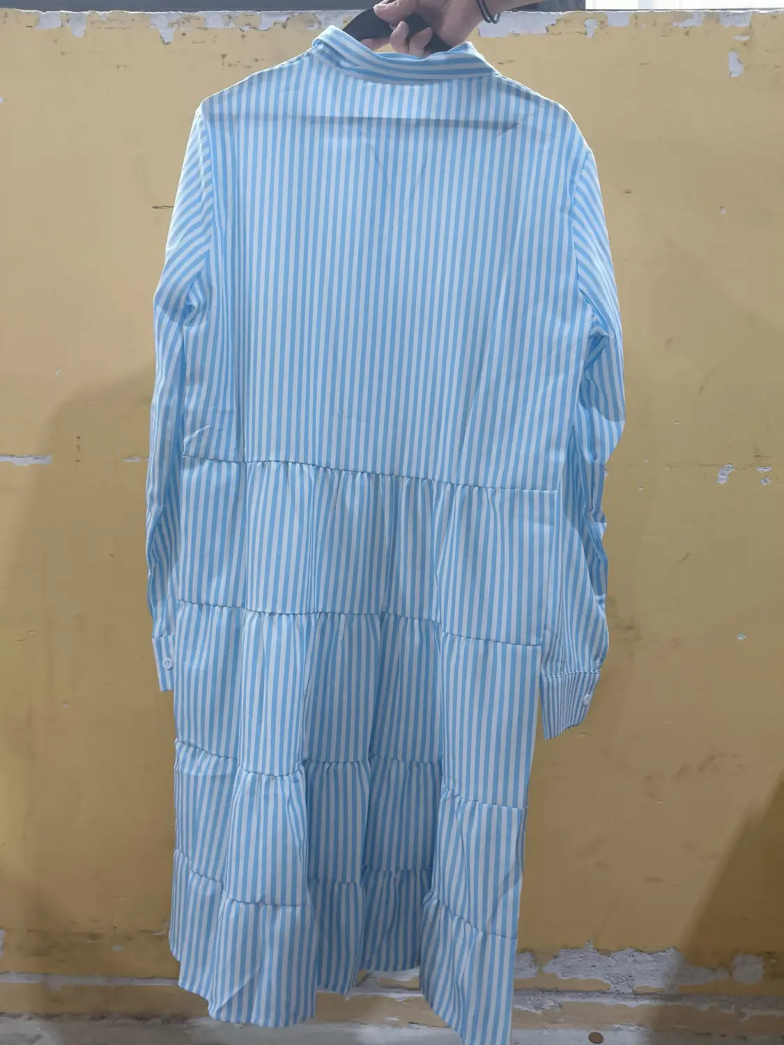 Robe chemise à volants étagés rayée verticalement bleu clair et blanc à manches longues, avec un col montant haut en tissu doux.