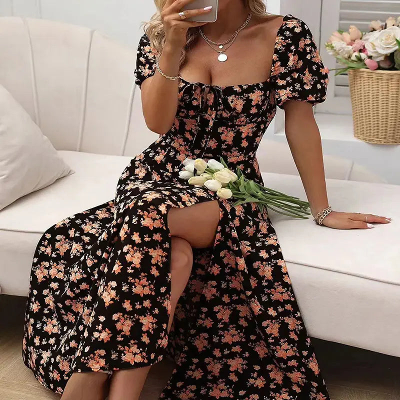 black floral maxi dress with pink and white blossoms featuring a square neckline, puffed short sleeves, and a side slit