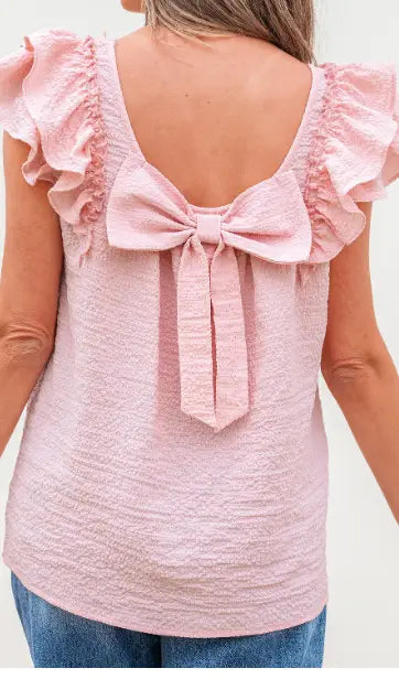 Back view of a pink textured square neck butterfly sleeve blouse featuring ruffled fabric and a matching bow.