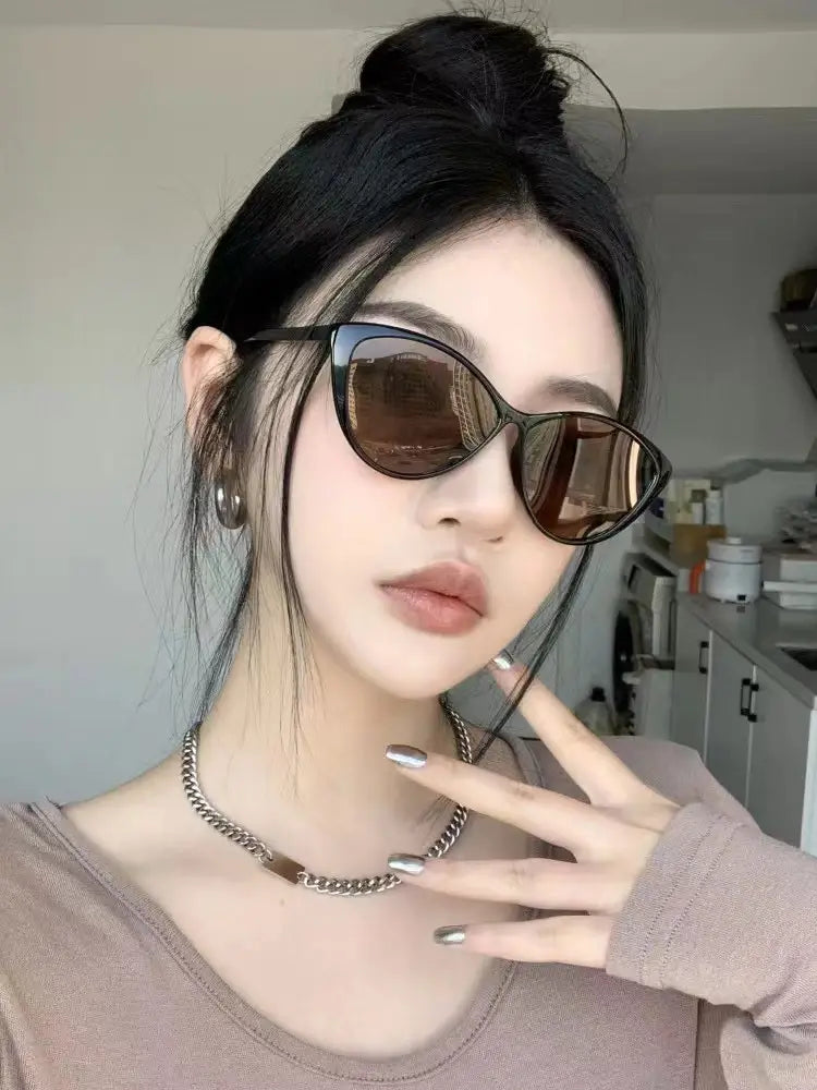 Lunettes de soleil rétro œil-de-chat UV380 légères pour la mode, avec des verres brun foncé et un cadre noir élégant.
