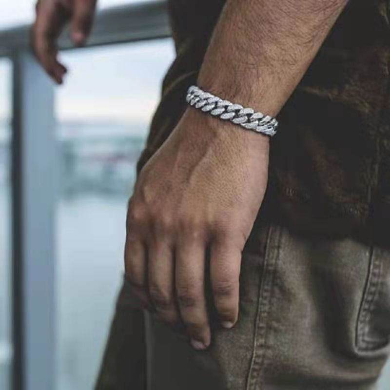 un collier pour animal en chaîne cubaine ton argenté « glacé » porté au poignet d’un homme, mettant en valeur son design de chaîne robuste