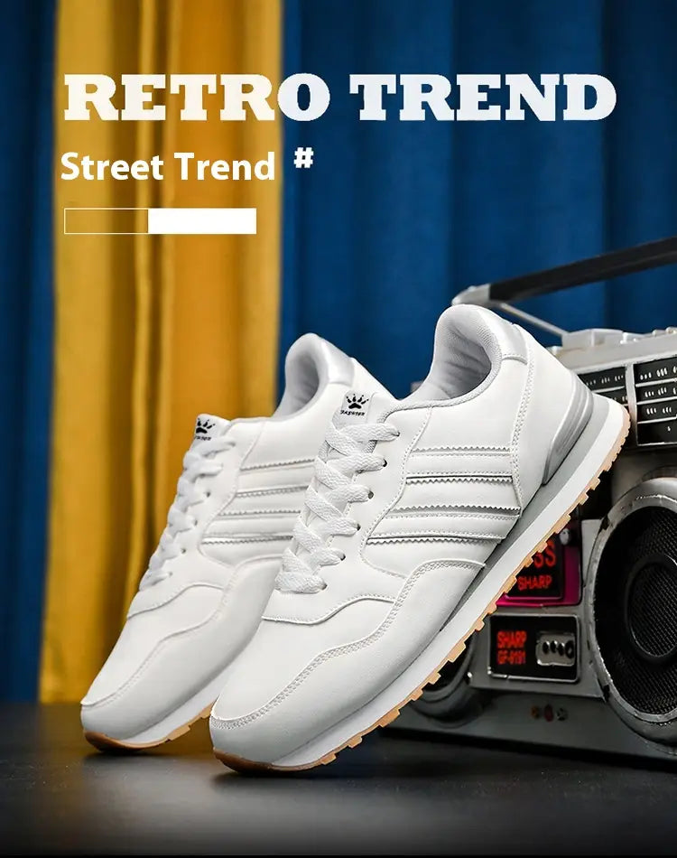 Baskets de sport rétro en cuir blanc pour la course, style décontracté, comportant un design classique à trois bandes et des semelles de couleur gomme.