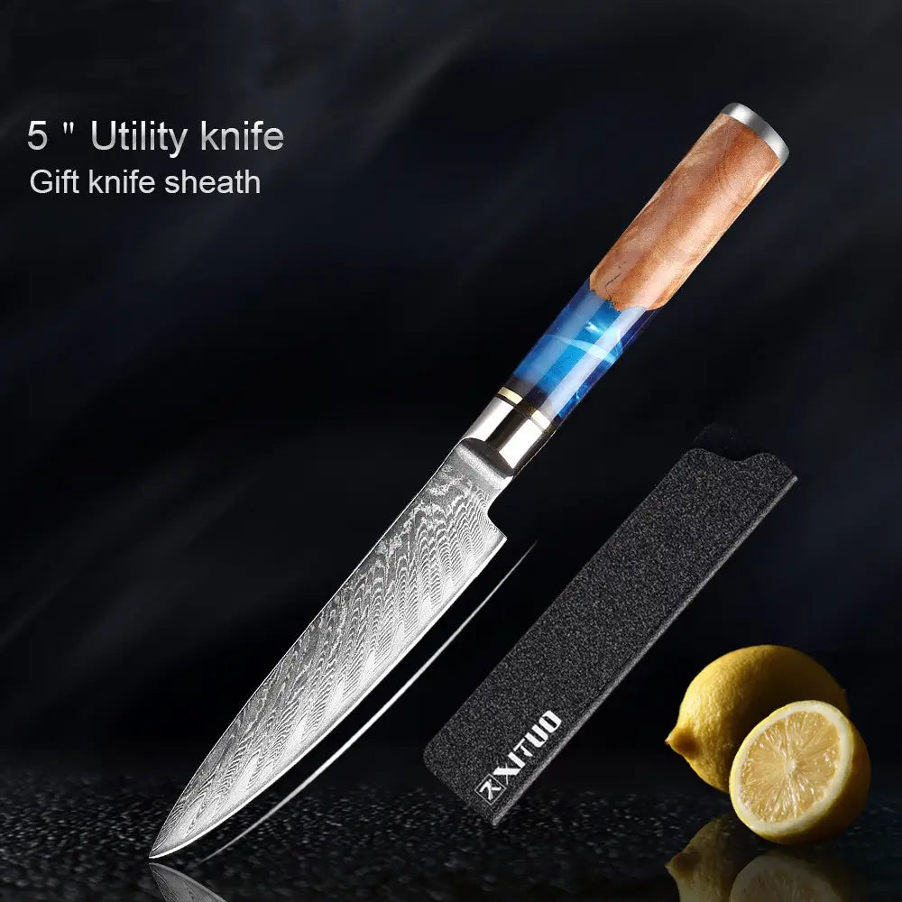 Un cuchillo utilitario de 5 pulgadas del set de cuchillos de chef damasco con hoja de acero damasco y mango de resina azul con detalles de madera, exhibido con su funda negra de regalo.