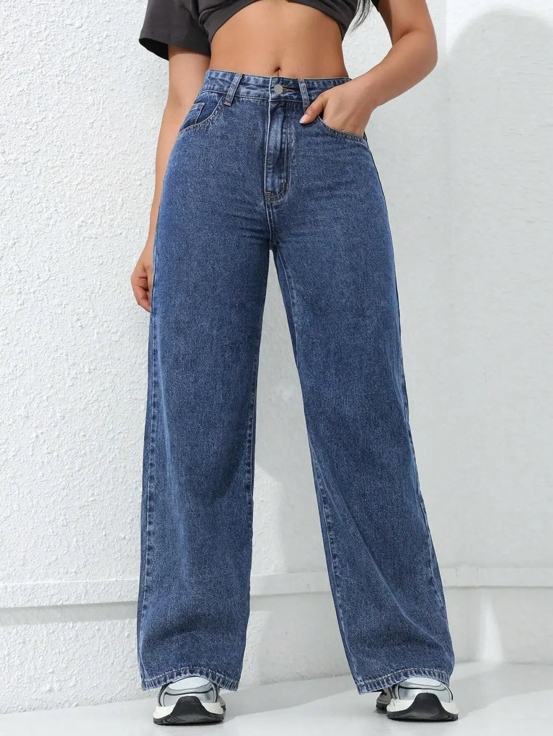 Jean à taille haute, jambe large et évasée, en denim bleu, présentant une coupe ample et une couture classique.