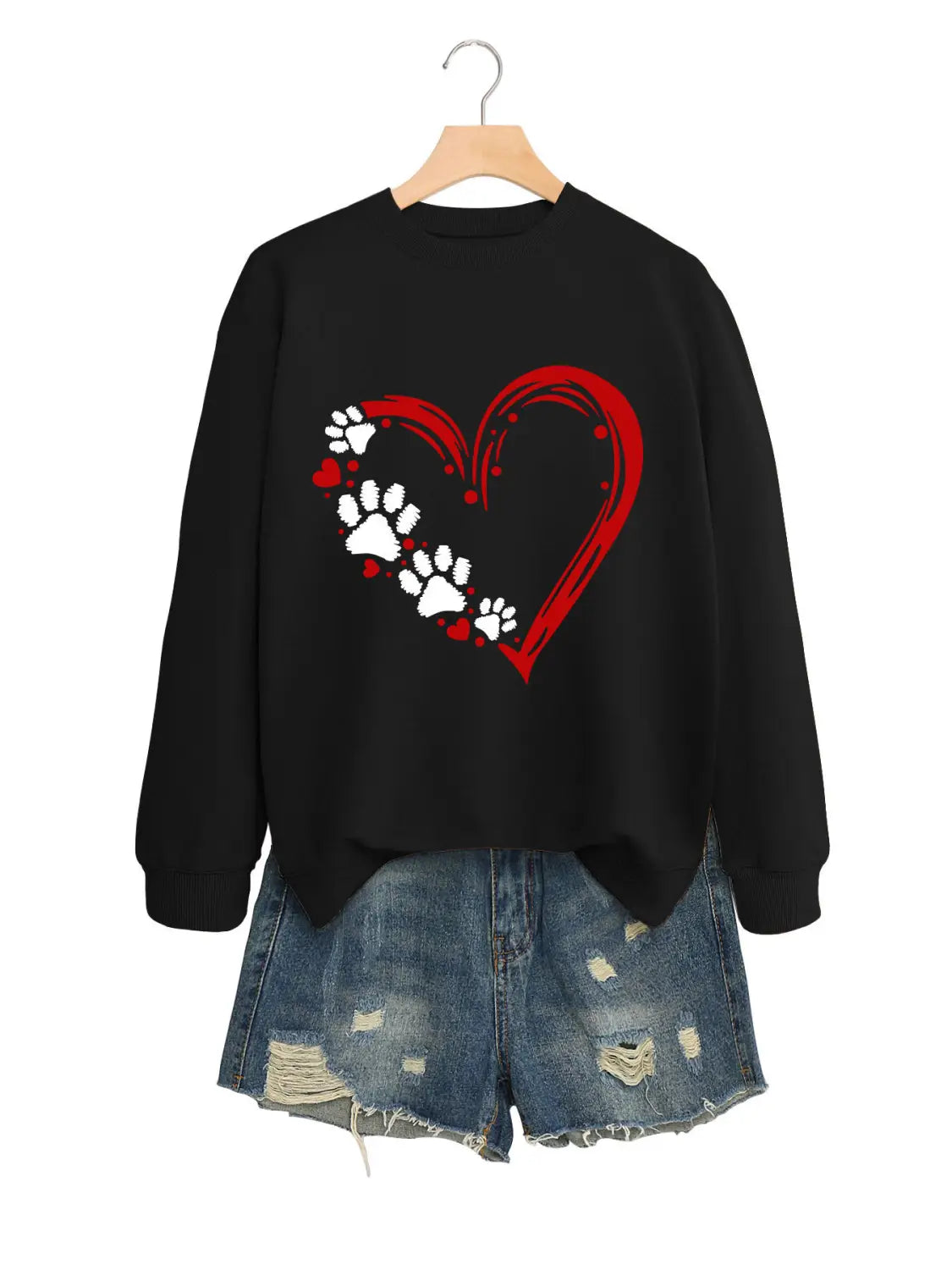 Sudadera negra de manga larga confeccionada con tejido suave, con diseño de corazón rojo y huellas de pata blancas, para uso casual.