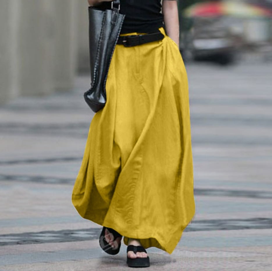 Une jupe longue maxi en satin taille haute jaune moutarde fluide, avec une silhouette ample à jambes larges et drapée de manière relaxée.