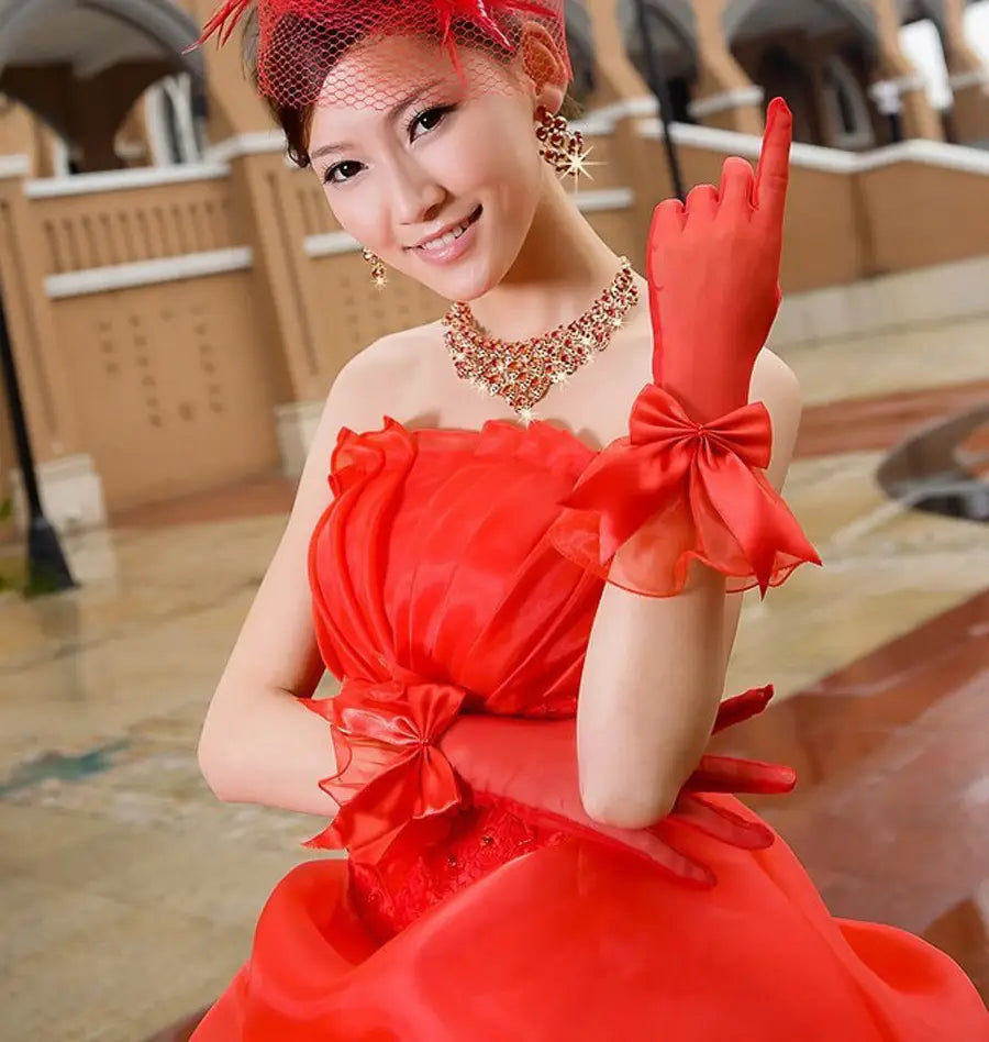 red satin evening gloves with matching bows at the wrist complementing elegant black lace and satin bow design.