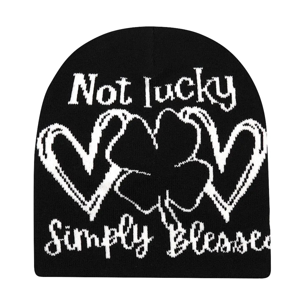 Black knit beanie winter warm hat featuring white knitted text not lucky and simply blessed with a central shamrock design surrounded by three hearts.