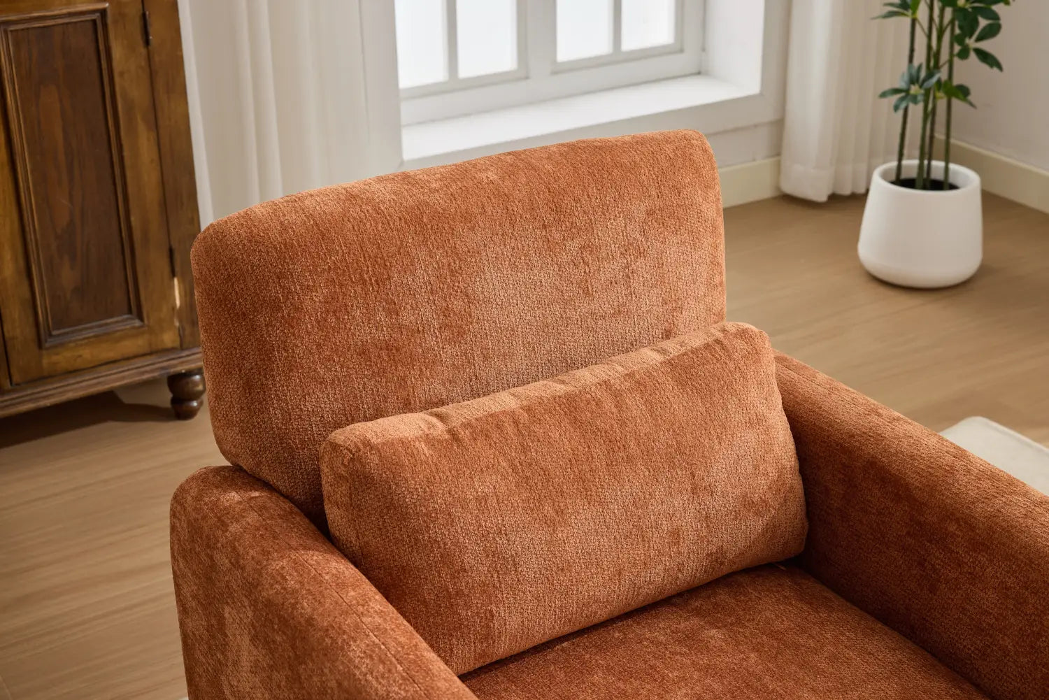Ein moderner Bouclé-Akzent-Sessel mit rustfarbenem, strukturiertem Stoff, mit plüschigen Kissen.