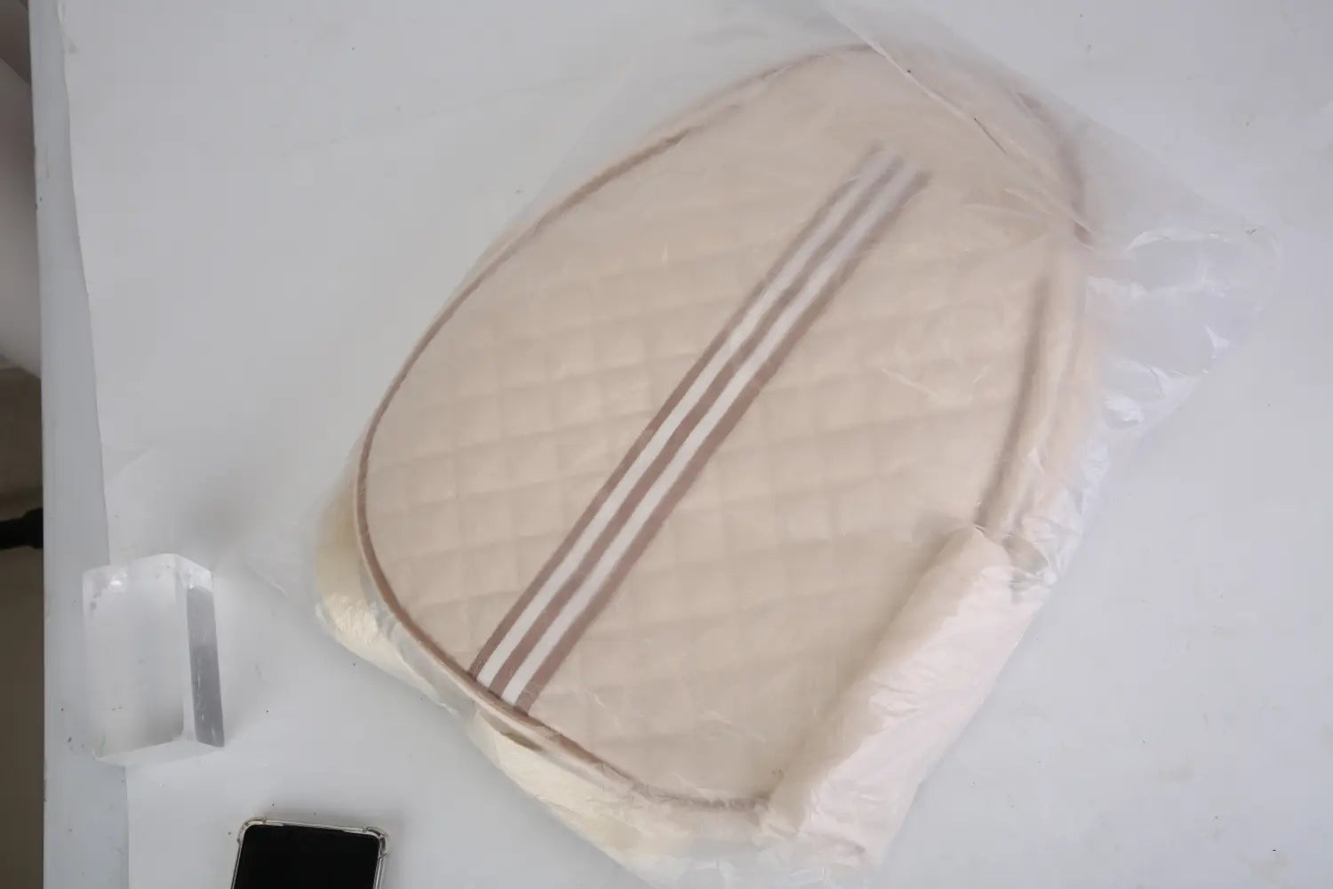 coussin matelassé beige de forme ovale, avec deux rayures brunes parallèles, pour un sac bandoulière imperméable de pickleball avec poche humide