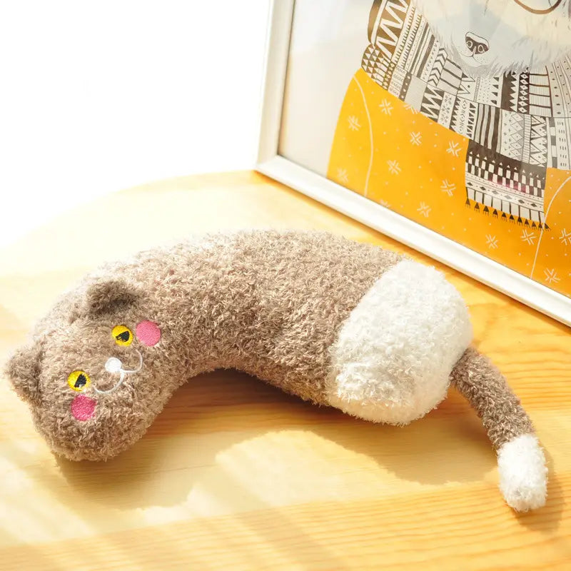 Ein weiches Plüsch-Katzen-Nackenkissen in Grau und Weiß mit bestickten gelben Augen und rosa Wangen, ausgelegt für Nackenunterstützung und Gelenkentlastung.