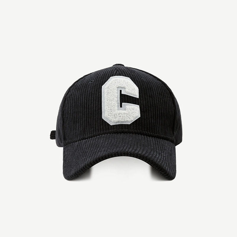 Black corduroy baseball cap featuring a prominent white textured embroidered letter c on the front.