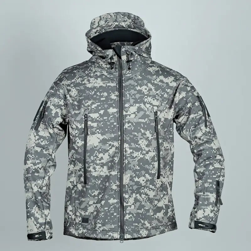 Veste tactique softshell à capuche en camouflage numérique gris, avec tirages de fermeture éclair noirs et poignets renforcés.