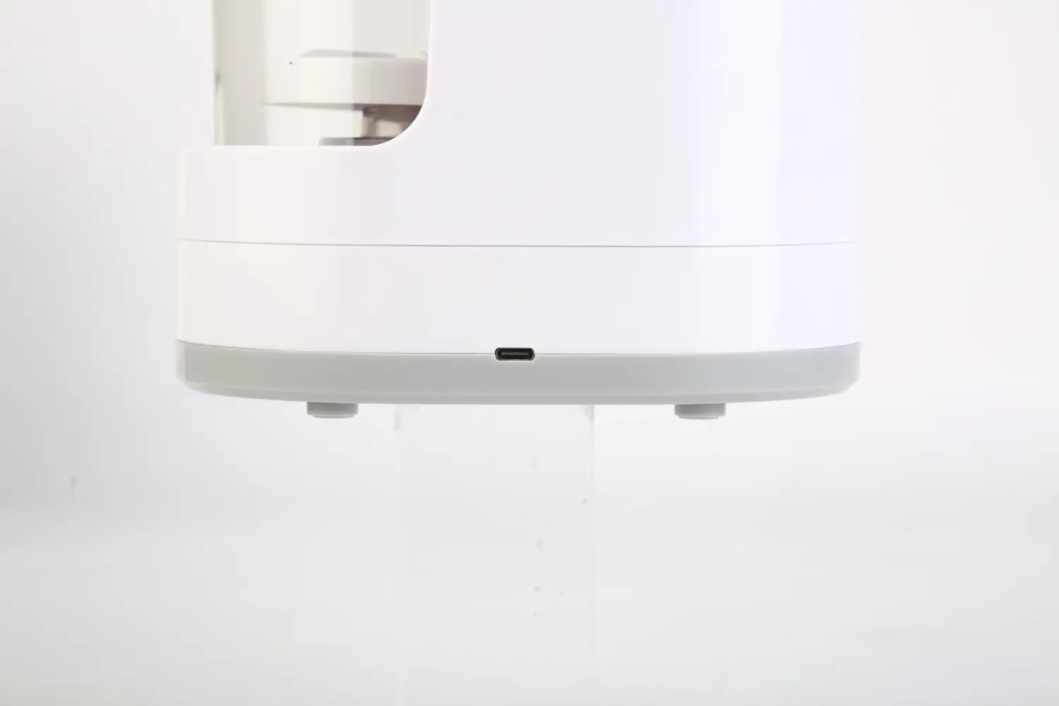 White and gray plastic base of a Xiaomi electric makeup brush cleaner UV sterilizer and dryer shown from the back side.