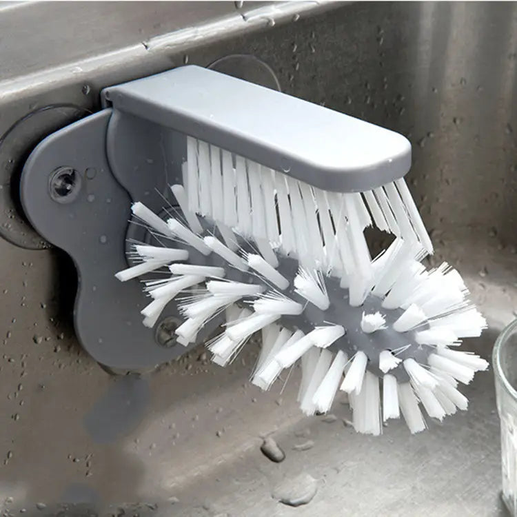 Gray plastic wall-mounted glass cleaning brush with white bristles and suction cup sink scrubber for efficient cleaning.