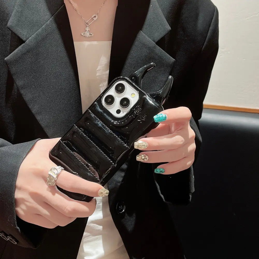 Black glossy devil horn quilted leather iPhone case with raised ridges and metallic accents shown from the back side