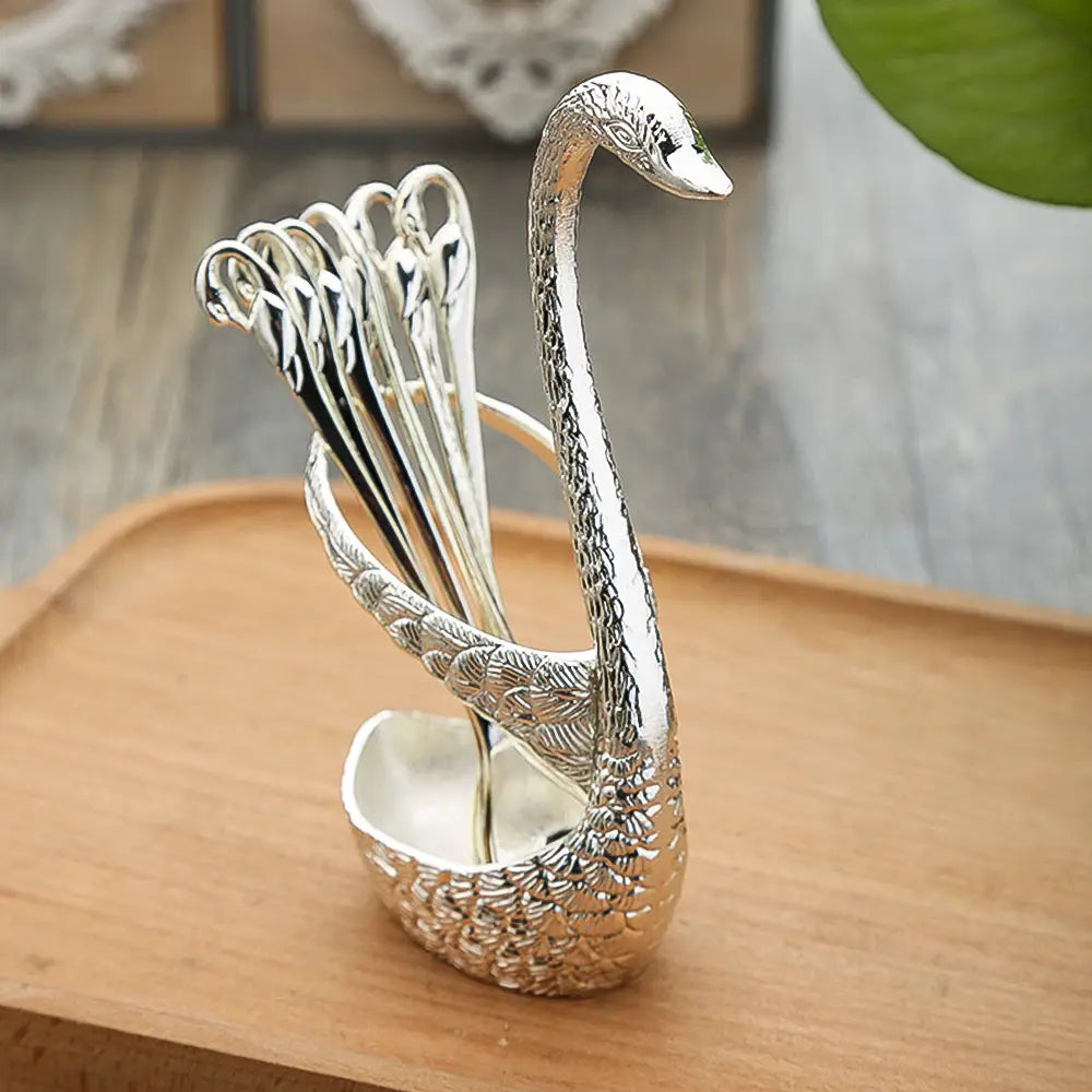 Porte-cuillère en forme de cygne argenté, orné de détails délicats de plumes et d’une finition métallique polie, issu du Coffret de coutellerie en cuillères et fourchettes à dessert dorées Swan Cutlery Set.