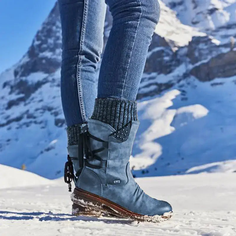 Women winter snow boots suede mid calf martin shoes in blue with black laces, brown sole, and decorative studs on the side.