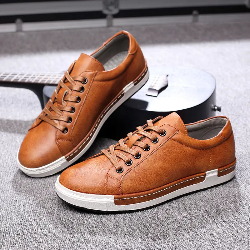 Les baskets basses en cuir pour homme, faites à la main, de couleur marron, avec un design à lacets, des semelles en caoutchouc blanc et des coutures contrastantes, pour un usage décontracté