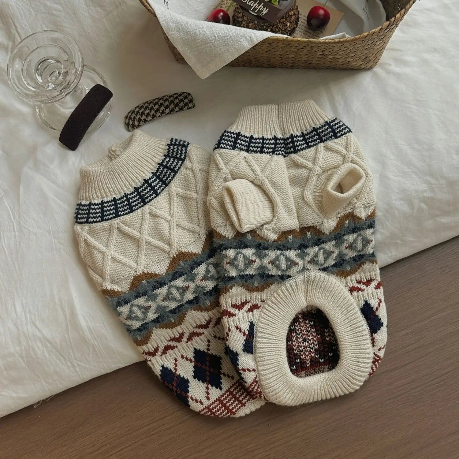 Pull pour chien tricoté couleur crème avec des motifs en torsades complexes et des motifs géométriques vintage dans des tons bleu marine, brun et gris, comprenant un col côtelé confortable et une poche avant.