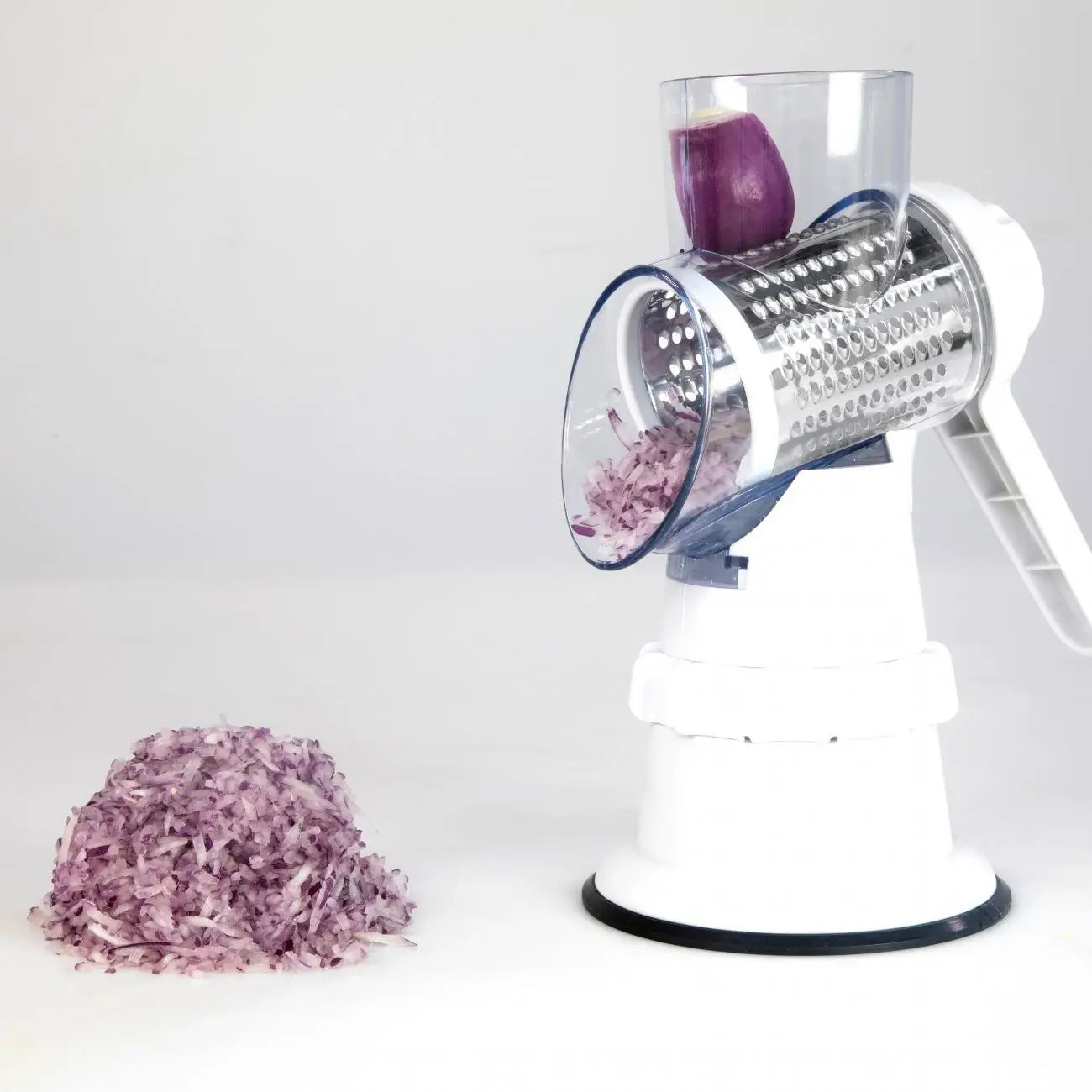 Gemüseschneider 3-in-1 manuelle rotierende Reibe, Mandoline in Weiß und klarem Kunststoff mit Mechanismus aus Edelstahl zum Reiben, der die rote Zwiebel fein zerkleinert.