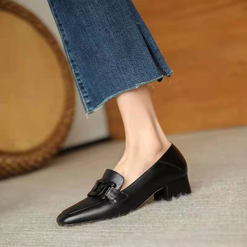 Black leather loafers with metal buckle square toe pumps featuring a small block heel and decorative metal buckle on the vamp.