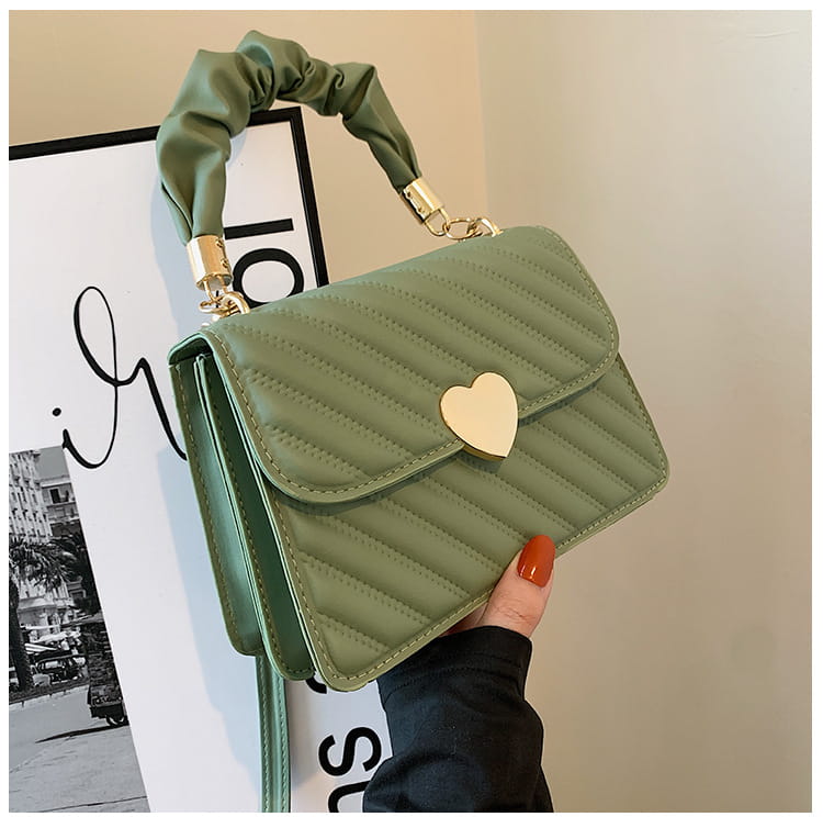Olive green quilted crossbody bag with ruched top handle and gold-tone heart-shaped clasp in formal leather design.