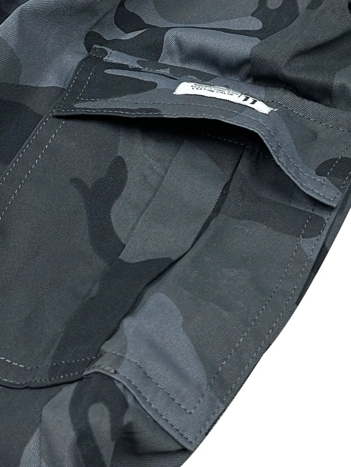 Short cargo camouflage gris foncé pour homme, coupe ample, conception à poches multiples, style utilitaire et coutures renforcées.