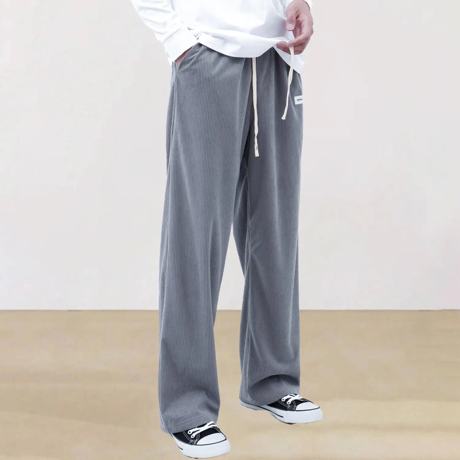 Men’s slim fit gray corduroy sport drawstring casual pants with a relaxed wide-leg cut and white drawstrings.
