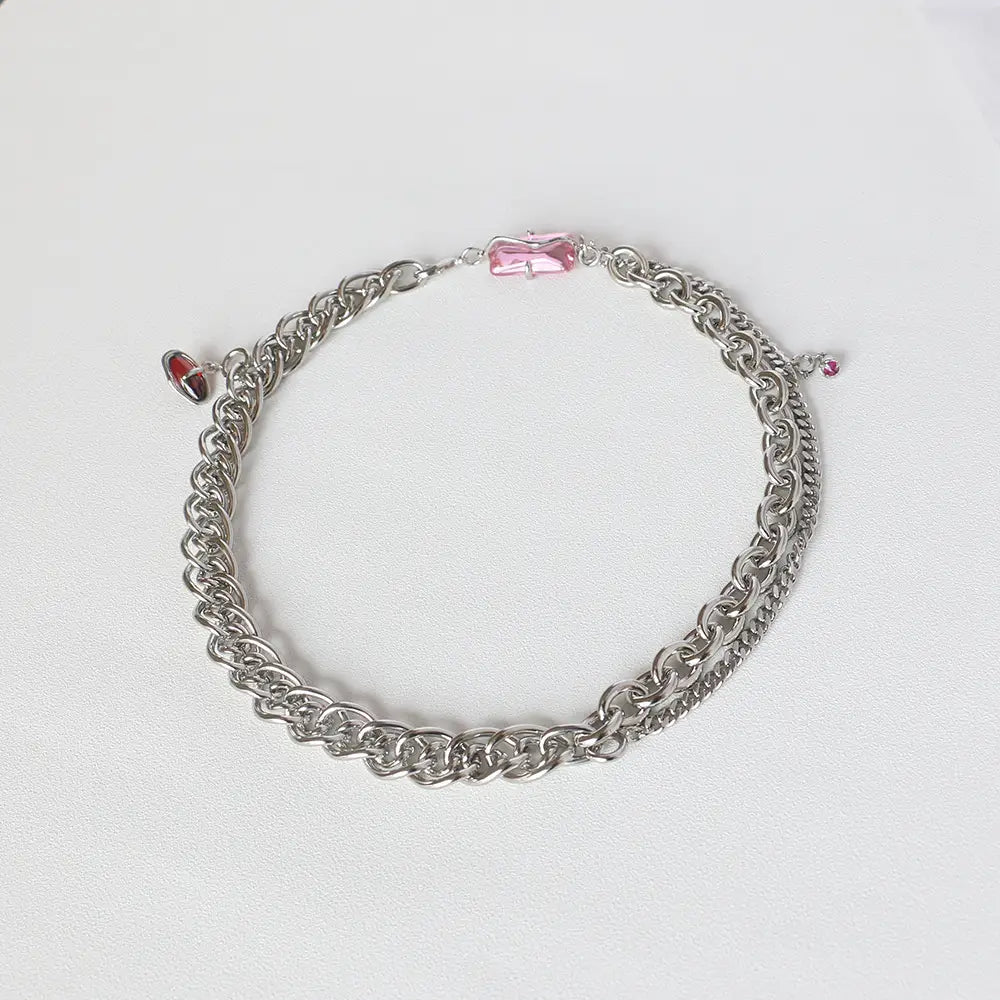 Layered silver opal and zircon crystal charm necklace featuring a silver chain with a pink rectangular crystal clasp and a small red heart charm.